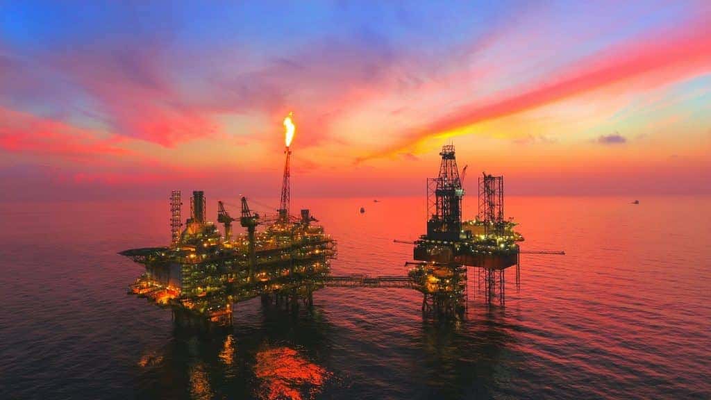oil rig in the middle of the sea at sunset